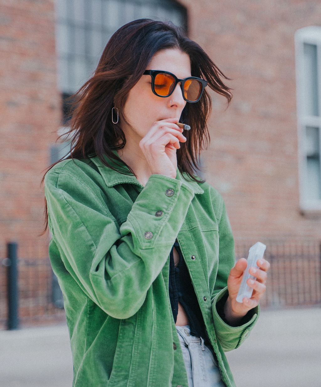 Woman holding joint case with 5 pre rolled cones. smoking a pre-roll