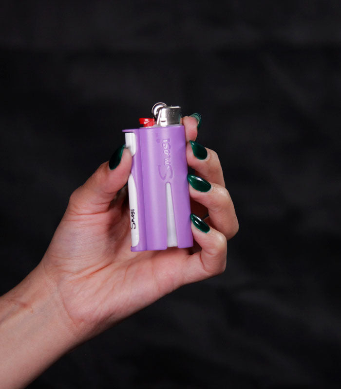 hand holding a Smosi PaL. lighter holder with a one-hitter pipe